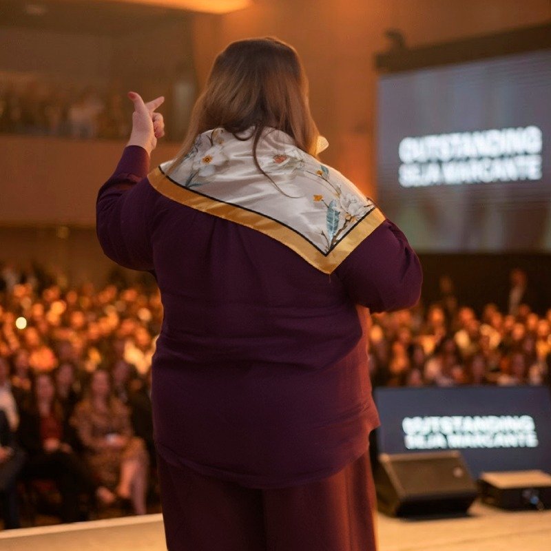Kátia de costas para o público, tela Outstanding